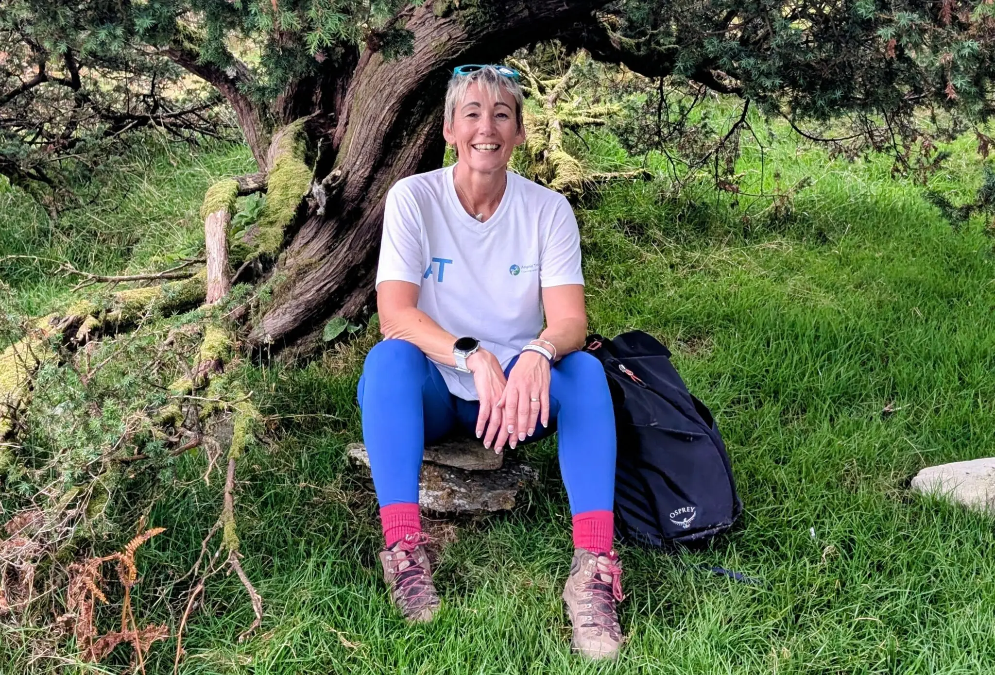Angela Topping sitting outdoors beneath a tree
