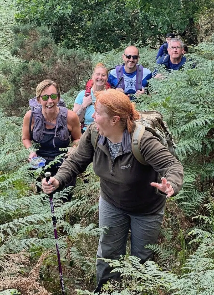 Walkers smiling as they make their way through bracken